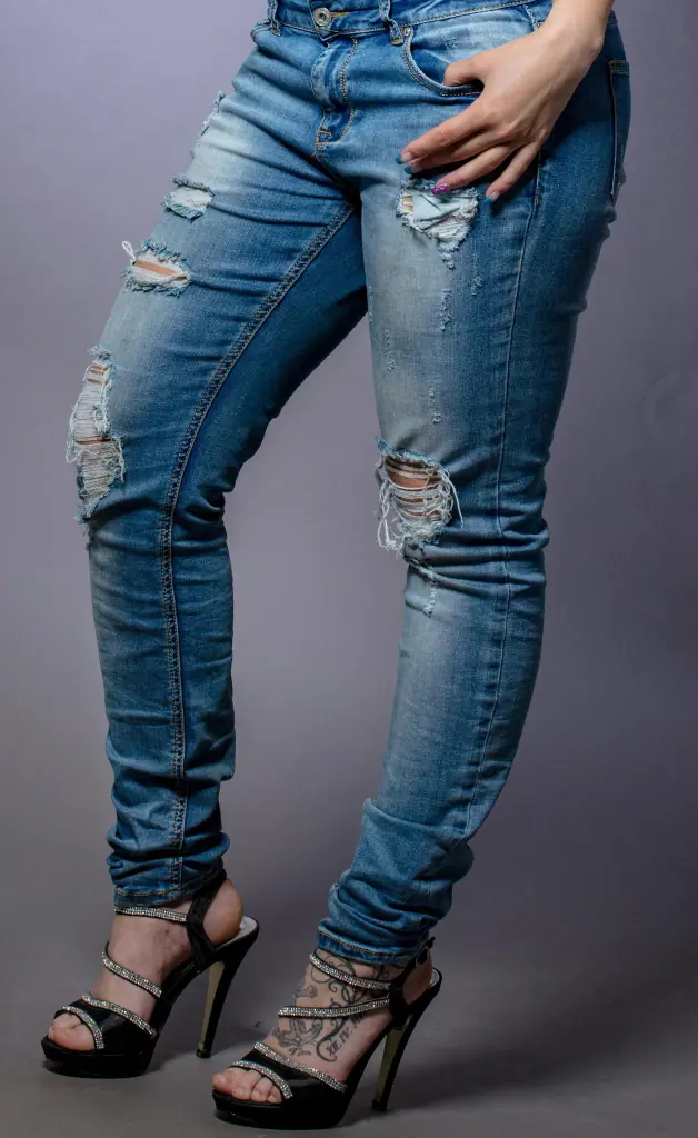 A girl’s leg is visible, showing she is wearing tight jeans.